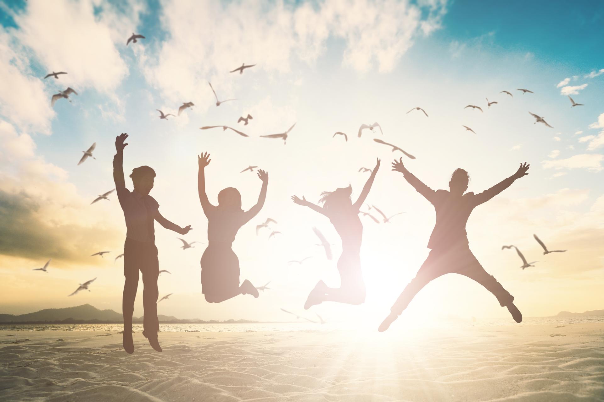 People jumping on beach celebrating freedom